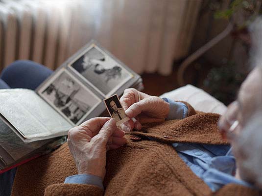 Elderly man looking at photo at a Walnut Creek Senior Community from Tiffany Court of Walnut Creek