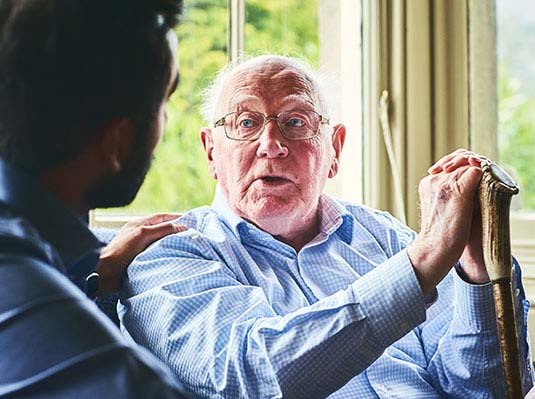 Elderly man talking to middle aged man at a Walnut Creek Senior Community from Tiffany Court of Walnut Creek